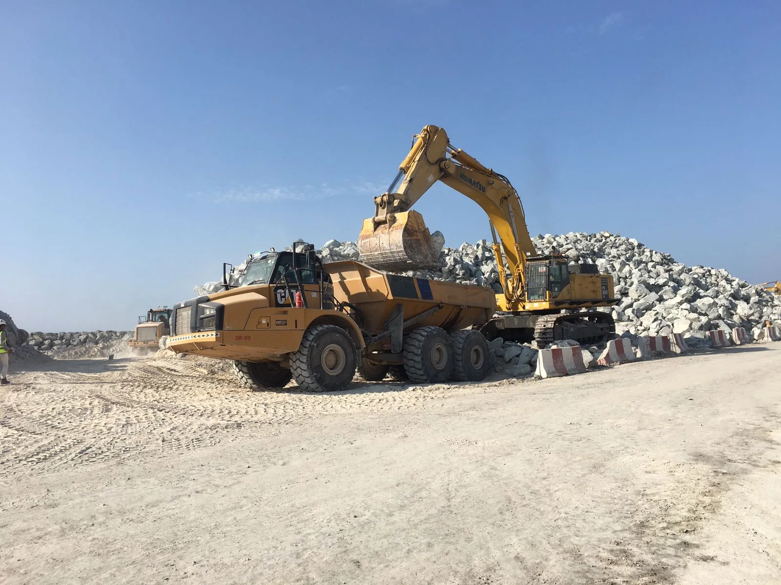 CAT articulated hauler being loaded by a Komatsu excavator