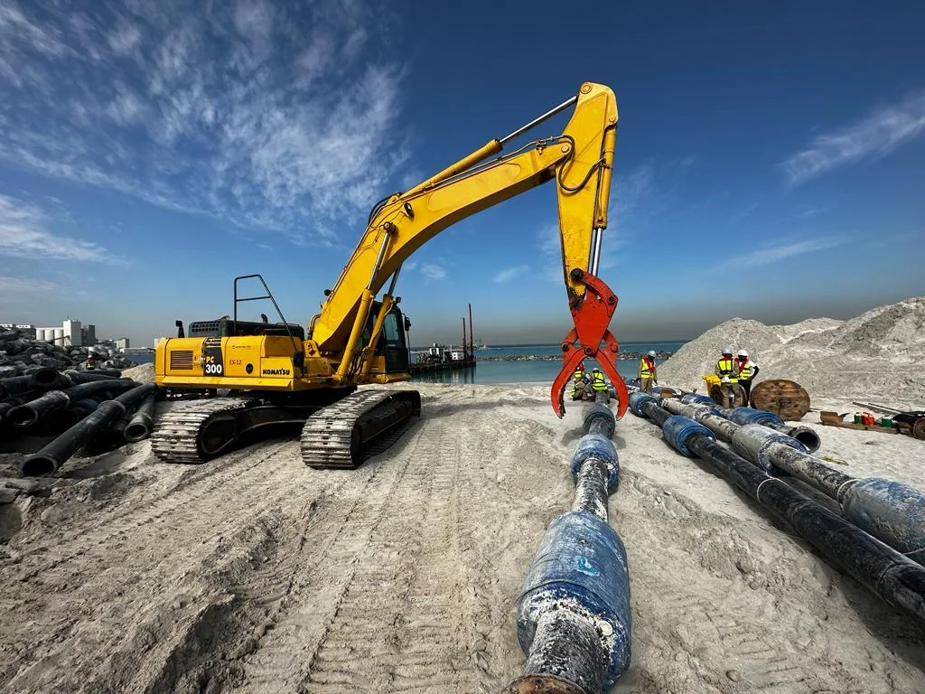 Marafi Komatsu PC300 excavator beside a shoreline pipeline
