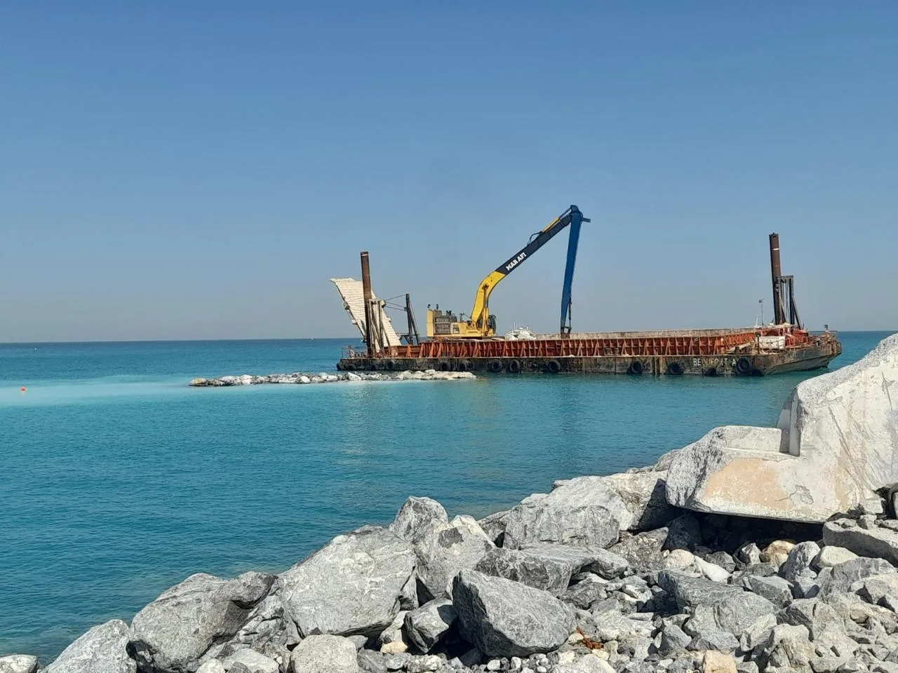 Marine construction barge viewed from the rock shoreline at Mamsha and Nobu.