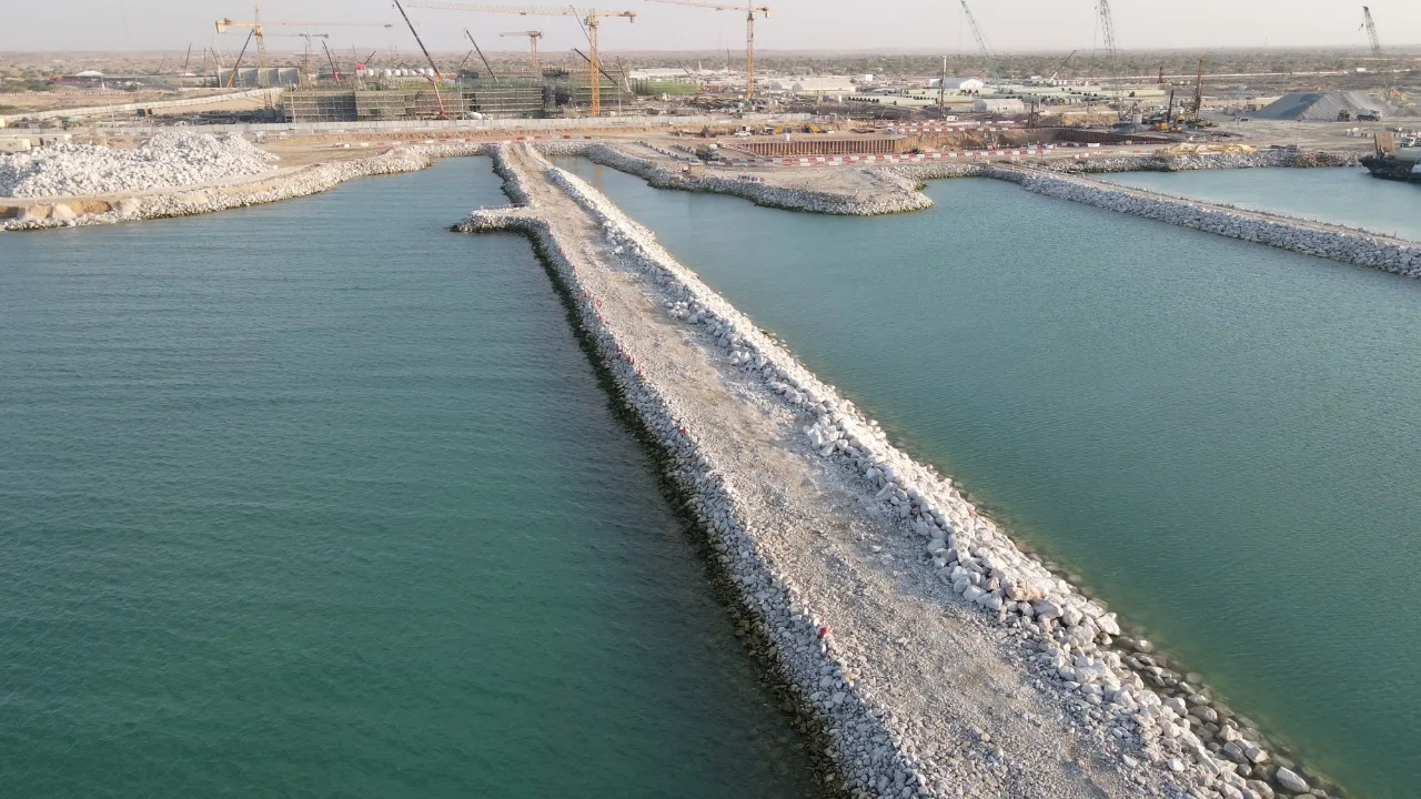 Rock breakwater extending towards the NAQAA shoreline.